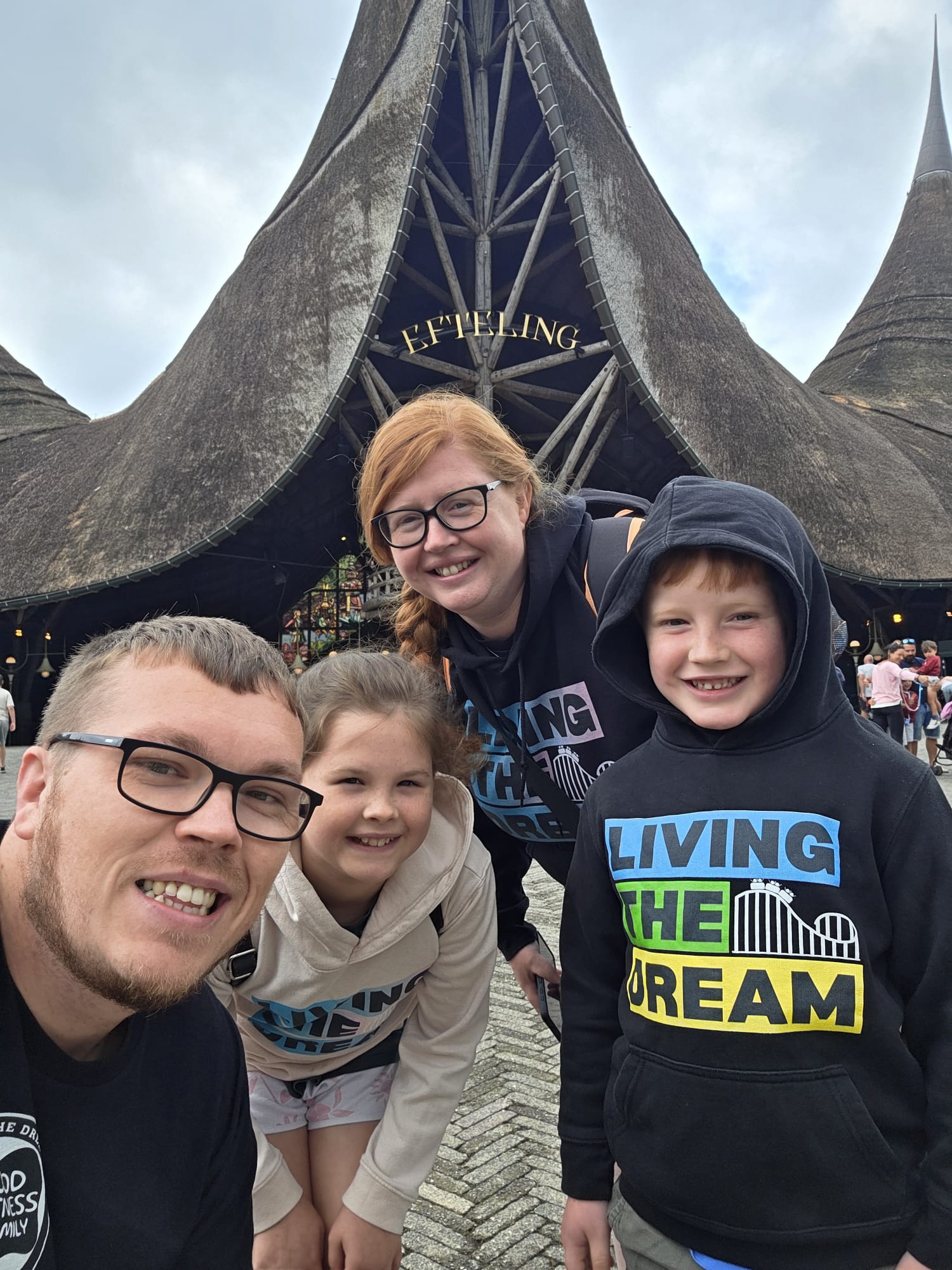 The family, smiling together at a theme park